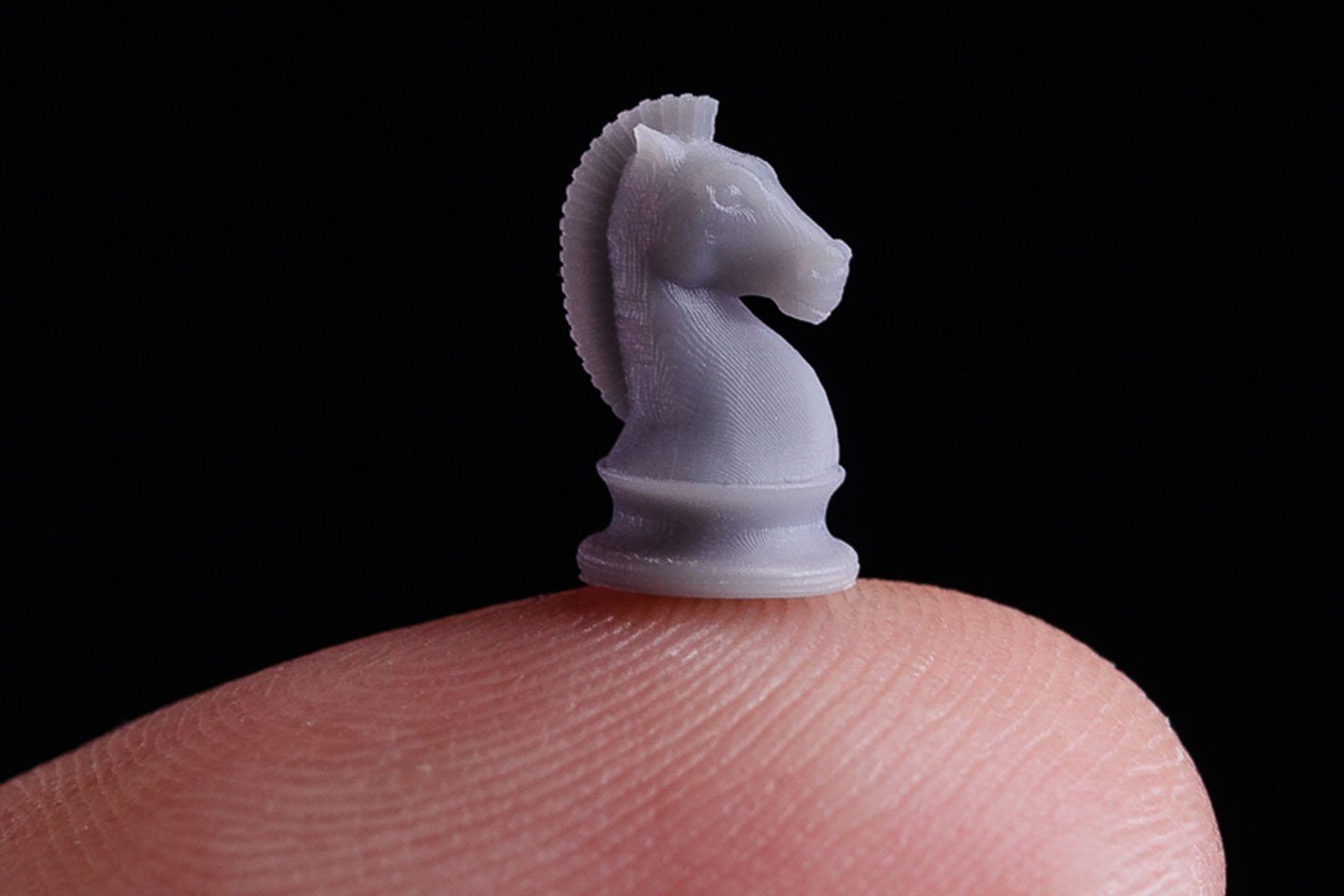 Miniature of horse chess piece on fingertip